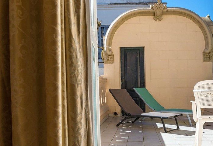 Hotel Noucentista gay-friendly hotel balcony view. Relaxing space with sun loungers. Perfect for gay travel. Stylish, comfortable stay.