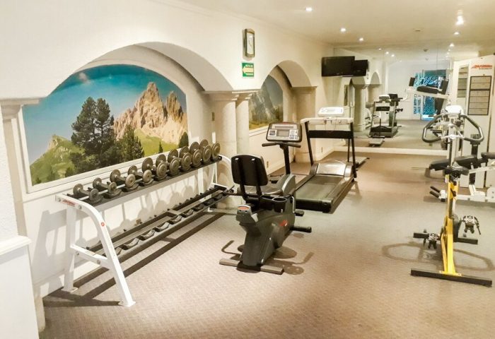 Hotel PF's gay-friendly gym. Weights, treadmill, exercise bike. Mountain mural. Fitness center for gay men travelers. Hotel PF.