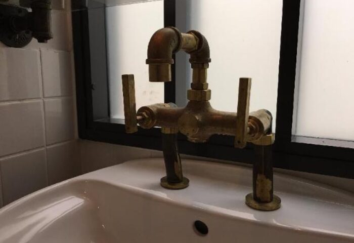 Gay-Friendly Hotel PaPa Whale: Bathroom sink with unique brass faucet. A stylish detail in this gay hotel, perfect for your gay travel.