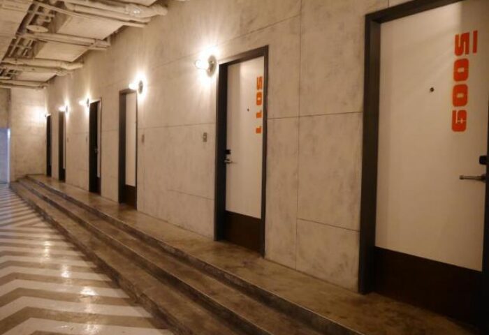 Hotel PaPa Whale's gay-friendly interior: A corridor with room doors. Modern design, unique room numbers. Ideal for gay men travel.