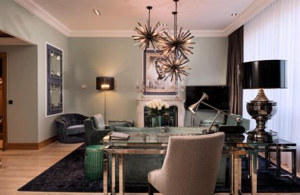 Hotel Palace Berlin's pet-friendly room. Gay-friendly hotel living room with modern design, chandeliers, and stylish furniture.