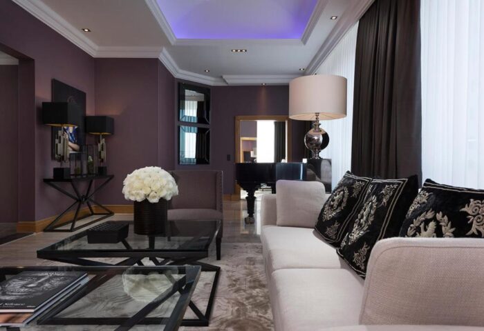 Hotel Palace Berlin's gay-friendly, pet-friendly suite. Living room with piano, sofa, and stylish decor. Luxury stay for gay travelers.
