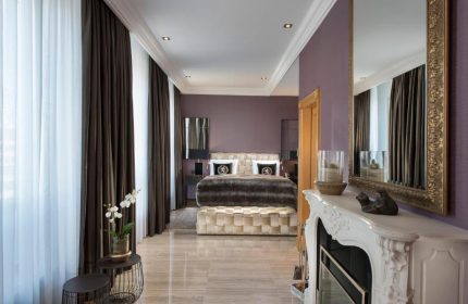 Hotel Palace Berlin gay-friendly room. Pet-friendly hotel with luxury bedroom, fireplace, mirror, and stylish decor. Ideal for gay travel.
