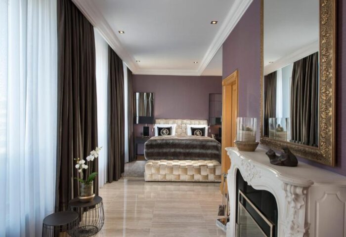 Hotel Palace Berlin gay-friendly room. Pet-friendly hotel with luxury bedroom, fireplace, mirror, and stylish decor. Ideal for gay travel.