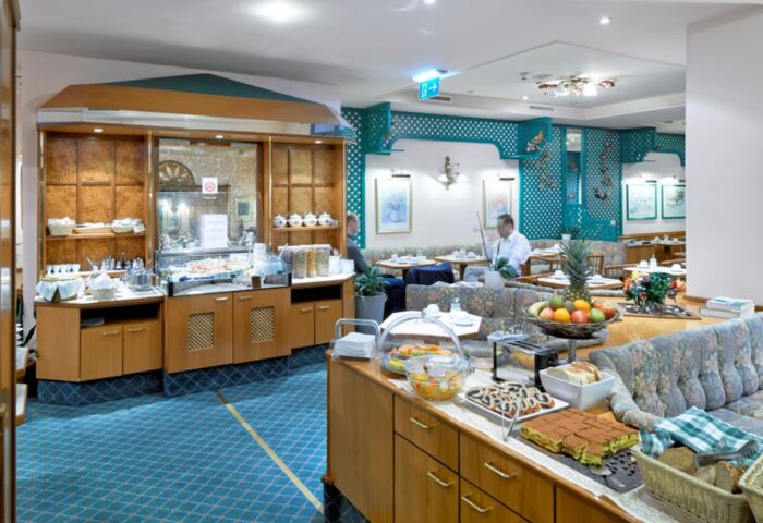 Breakfast buffet at Gay-Friendly Hotel Pensione Wildner. Guests enjoy fresh fruit, pastries, and a variety of breakfast items in Venice, Italy.