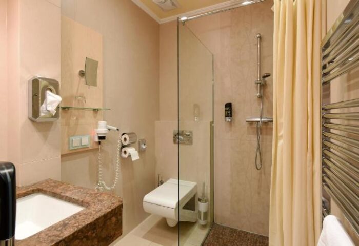 Hotel Pensione Wildner gay-friendly hotel bathroom with sink, toilet, and shower. Modern design, clean and comfortable. Gay travel advice.