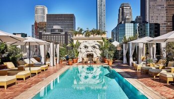 Rooftop pool at Gay-Friendly Hotel Per La, Autograph Collection. Lounge chairs, cabanas, and a unique sculpture with city skyline views.