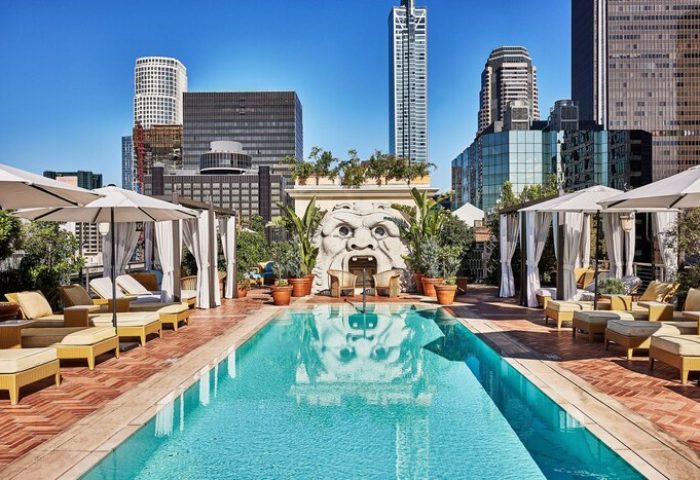 Rooftop pool at Gay-Friendly Hotel Per La, Autograph Collection. Lounge chairs, cabanas, and a unique sculpture with city skyline views.