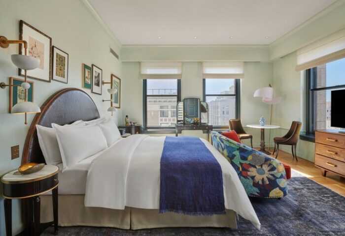 Hotel Per La, Autograph Collection room. Gay-friendly hotel bedroom with bed, blue throw, floral sofa, and city view. Upscale lodging.