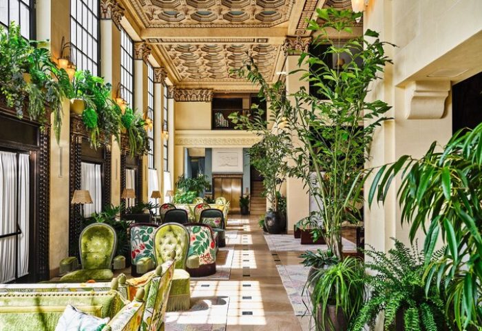 Hotel Per La, Autograph Collection's lavish lobby. Gay-friendly hotel with ornate ceilings, lush plants, and stylish seating. A luxury travel experience.