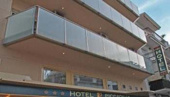 Hotel Piccadilly Sitges facade. Gay-friendly hotel with glass balconies. A great option for gay men's travel in Sitges, Spain.