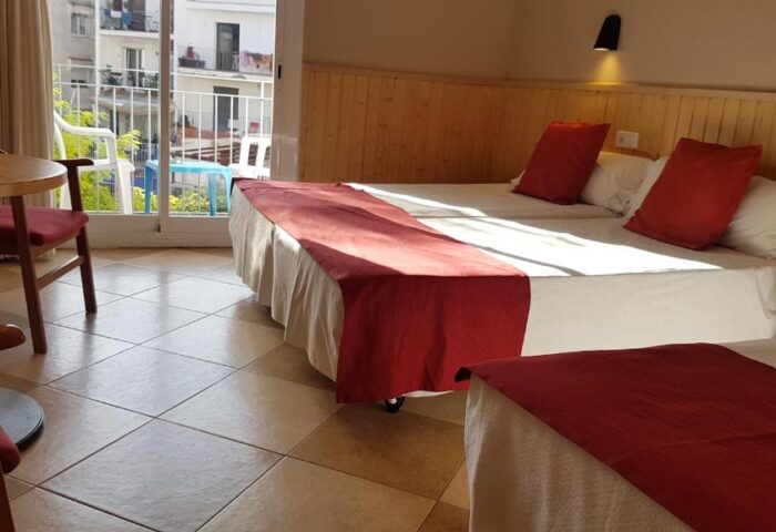 Hotel Piccadilly Sitges gay-friendly room. Beds with red accents, balcony view. Comfortable stay at this gay hotel in Sitges, Spain.