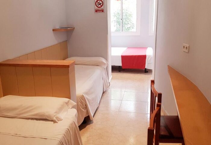 Hotel Piccadilly Sitges gay-friendly room. Twin beds, wood accents, tile floor. A comfortable stay at this Sitges hotel for gay travelers.