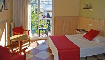 Hotel Piccadilly Sitges room. Gay-friendly hotel with balcony, bed, and chairs. Enjoy your stay at this Sitges hotel, a top choice for gay travel.