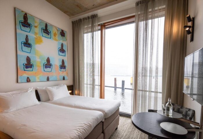 Hotel Pontsteiger's gay-friendly room with twin beds, modern art, and waterfront view. Ideal for gay men's travel in Amsterdam.