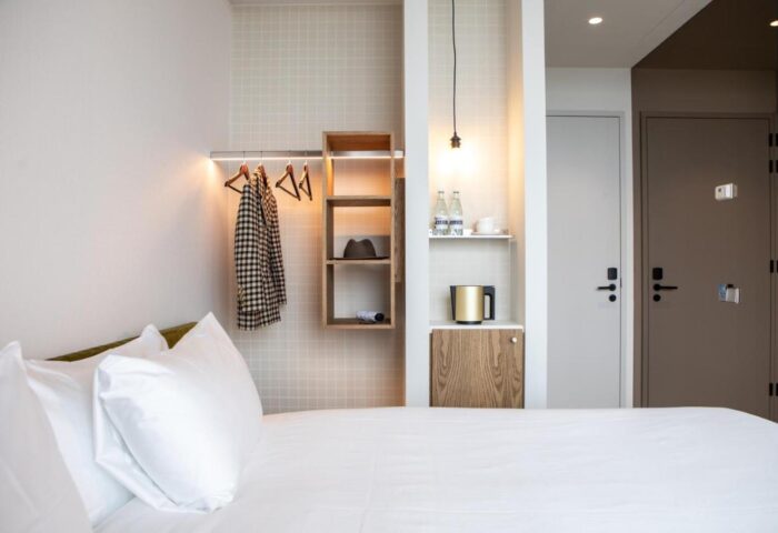 Hotel Pontsteiger room detail. Gay-friendly hotel room with white bed linens, closet, shelves, and modern design. Gay travel accommodation.