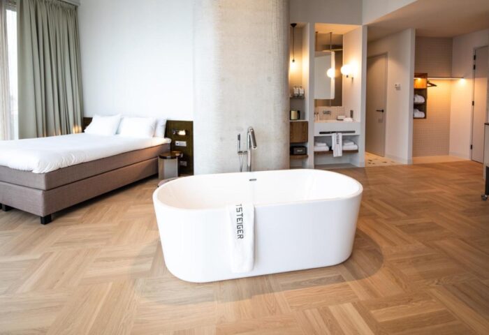 Hotel Pontsteiger gay-friendly hotel room. Modern design with bathtub, bed, and bathroom. Luxury gay travel accommodation.