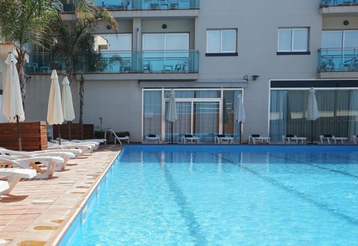 Hotel Port Sitges gay-friendly hotel pool view. Loungers & parasols surround the pool. A great place to relax in Sitges, Spain.