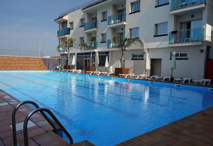 Hotel Port Sitges pool view. Gay-friendly hotel with outdoor pool, sun loungers, and palm trees. A great choice for gay men's travel in Sitges.