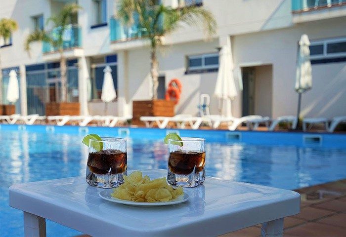 Hotel Port Sitges gay-friendly hotel pool. Drinks and snacks by the pool at a gay hotel in Sitges, Spain. Relaxing vacation.