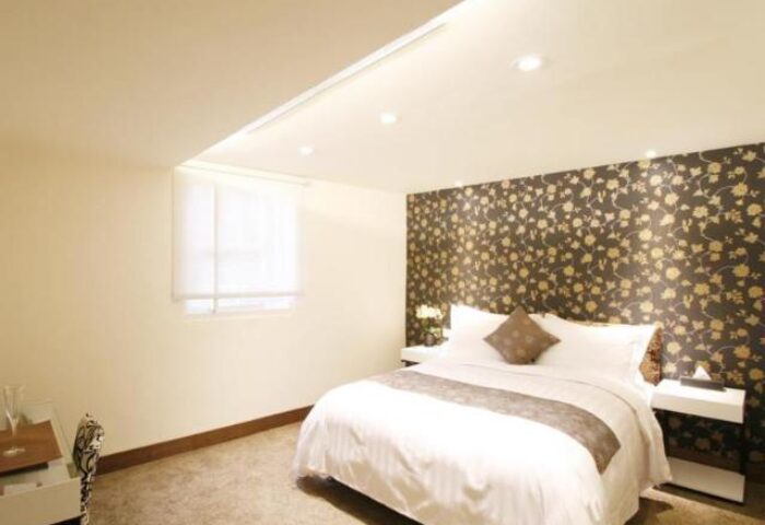 Hotel Puri Ximen room. Gay-friendly hotel bedroom with a double bed, floral wallpaper, bedside tables, and a window. Taiwan travel.