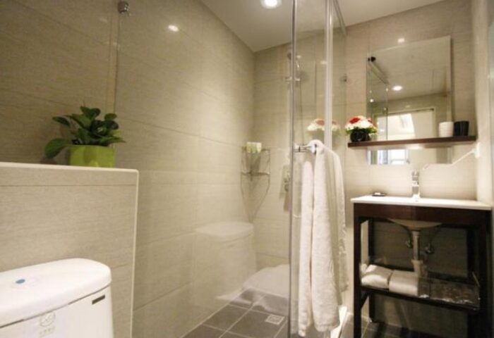 Hotel Puri Ximen bathroom. Modern design with glass shower, toilet, sink, and mirror. Gay-friendly hotel in Ximen, Taipei.