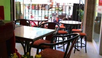Hotel Queens Adults Only By Mc: Interior view of the gay-friendly hotel's cafe, tables and chairs, outdoor seating area visible.