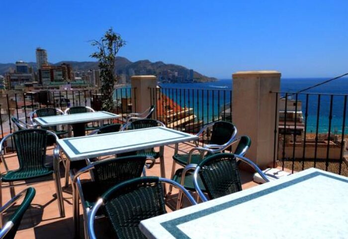 Hotel Queens Adults Only By Mc: Outdoor terrace with tables and chairs overlooking the sea. Gay-friendly hotel in a coastal city.