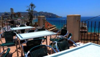 Hotel Queens Adults Only By Mc: Outdoor terrace with tables and chairs overlooking the sea. Gay-friendly hotel in a coastal city.