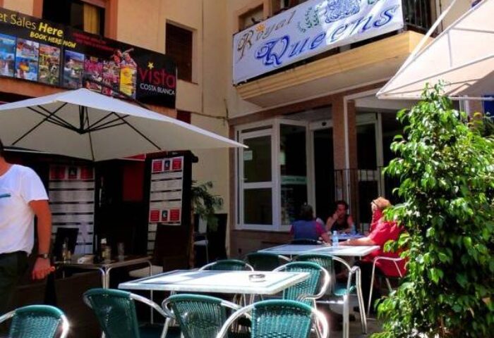 Hotel Queens Adults Only By Mc, a gay-friendly hotel. Outdoor dining area with tables, chairs, and sun umbrellas. Perfect for gay travelers.