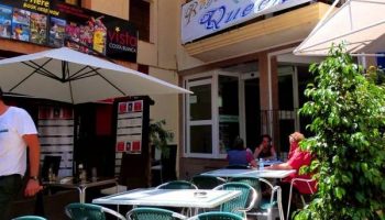 Hotel Queens Adults Only By Mc, a gay-friendly hotel. Outdoor dining area with tables, chairs, and sun umbrellas. Perfect for gay travelers.