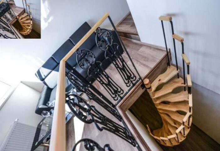 Hotel Residence Spalena's interior: spiral staircase, black iron railings, and a black leather couch. Gay-friendly hotel in Prague.
