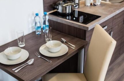 Hotel Residence Spalena's kitchenette. Gay-friendly hotel with dining table set for two, bottles of water, and cooking facilities.