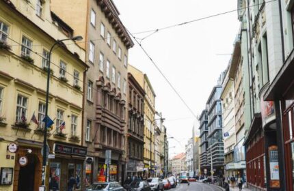 Street view of Hotel Residence Spalena, a gay-friendly hotel in Prague. Cars line the street between historic buildings. Great for gay travel.