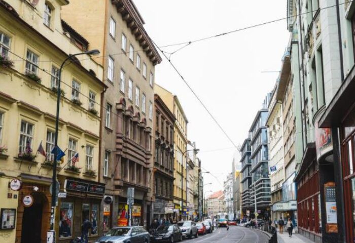 Street view of Hotel Residence Spalena, a gay-friendly hotel in Prague. Cars line the street between historic buildings. Great for gay travel.