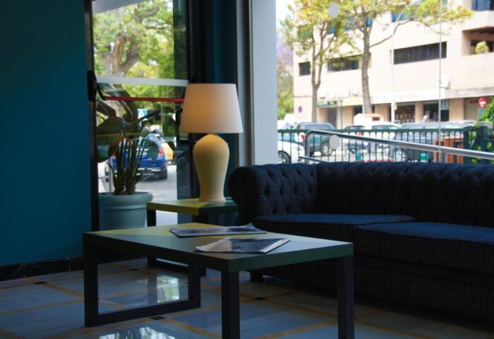 Hotel Ritual Torremolinos Adults Only gay-friendly hotel interior. Lobby seating area with sofa, tables, and lamp. Modern design.