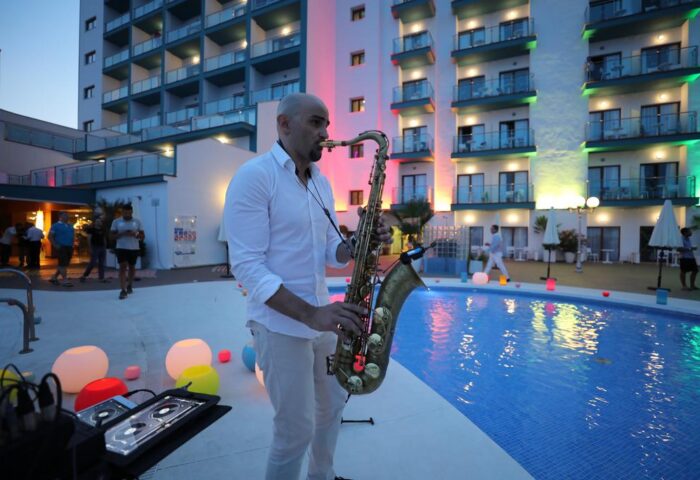 Saxophonist at Hotel Ritual Torremolinos Adults Only, a gay-friendly hotel. Poolside performance with colorful lights. Nightlife at this resort.