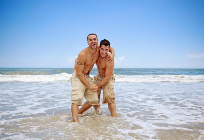 Gay-friendly Hotel Ritual Torremolinos: Two shirtless men smiling on the beach. Adults only resort, perfect for gay travel advice.