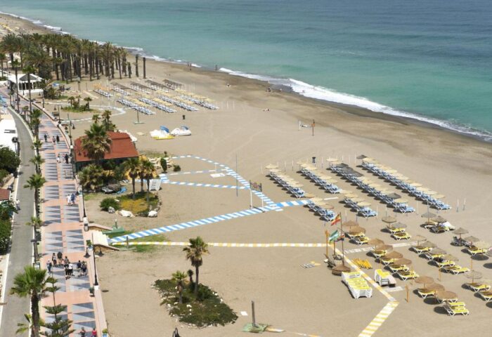 Torremolinos beach view from Hotel Ritual, an Adults Only gay-friendly hotel. Umbrellas and chairs line the sandy shore near the ocean.