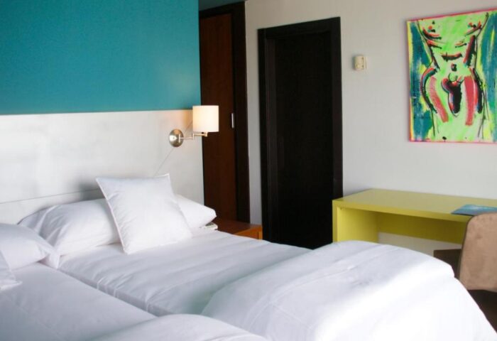 Hotel Ritual Torremolinos Adults Only gay-friendly room. Twin beds, desk, and suggestive art. Modern, clean design for gay travelers.