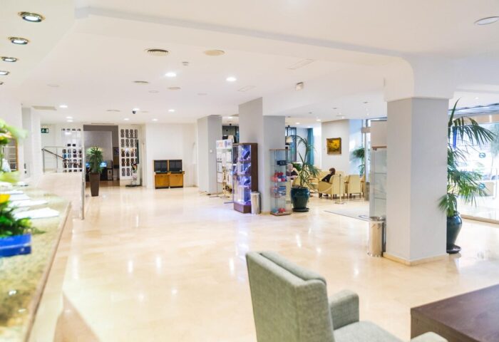 AluaSun Flamingo Hotel lobby. Gay-friendly hotel interior view with marble floors, seating area, and reception desk. Travel advice for gay men.