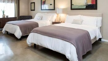 Hotel Royal's gay-friendly room with two beds. Modern decor, abstract art, and comfortable bedding create a welcoming space for gay travelers.