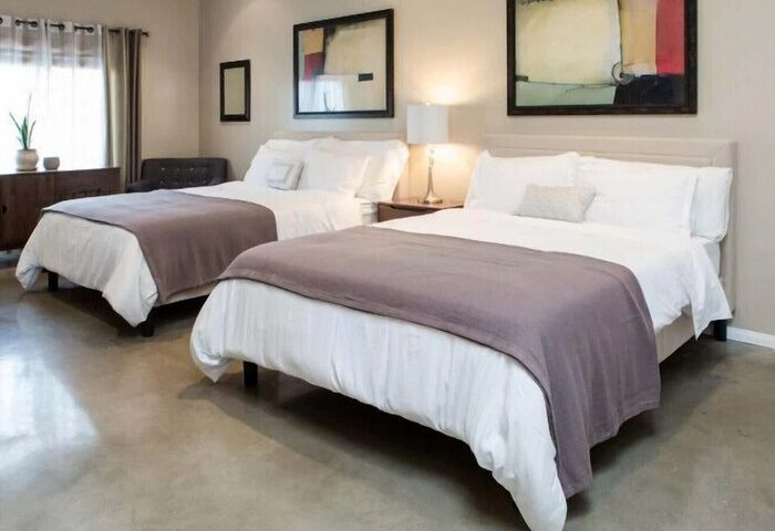 Hotel Royal's gay-friendly room with two beds. Modern decor, abstract art, and comfortable bedding create a welcoming space for gay travelers.