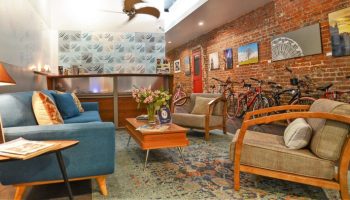 Hotel Royal's gay-friendly vibe: cozy lobby with exposed brick, bikes, and stylish furniture. Perfect for gay travelers seeking comfort.