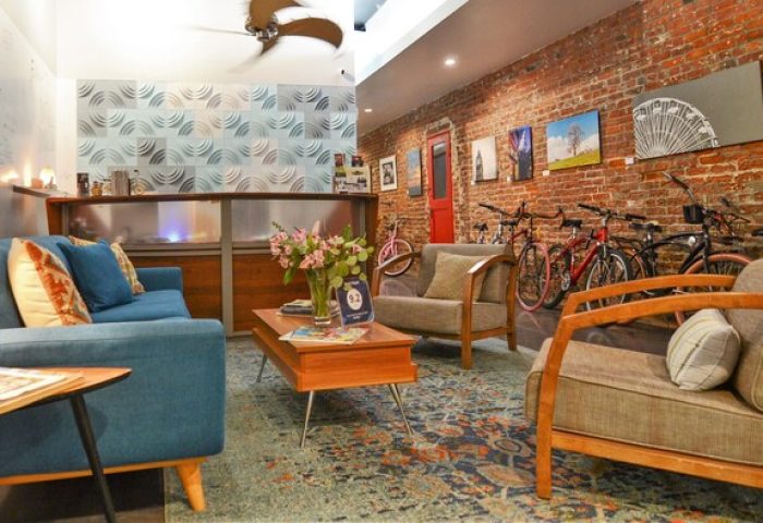 Hotel Royal's gay-friendly vibe: cozy lobby with exposed brick, bikes, and stylish furniture. Perfect for gay travelers seeking comfort.