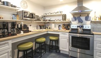 Hotel Royal's gay-friendly kitchen. Stainless steel appliances, coffee makers, and bar stools. A welcoming space for gay travelers.