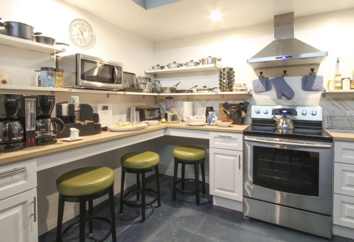 Hotel Royal's gay-friendly kitchen. Stainless steel appliances, coffee makers, and bar stools. A welcoming space for gay travelers.