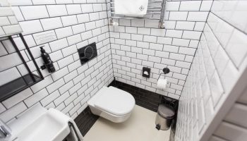 Hotel Rum Budapest gay-friendly hotel bathroom. White subway tile, modern toilet, sink, and accessories. Clean design in Budapest hotel.