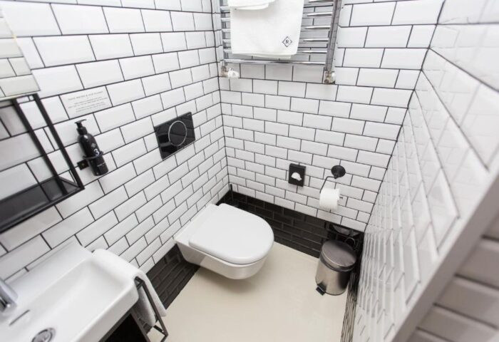 Hotel Rum Budapest gay-friendly hotel bathroom. White subway tile, modern toilet, sink, and accessories. Clean design in Budapest hotel.