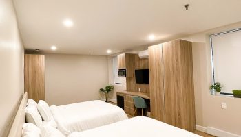 Hotel Saint-Andre gay-friendly room. Two beds with white linens, desk, TV, wood floors, and a window. Perfect for gay men travel.